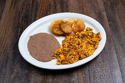 Chorizo scrambled with egg on an oval plate, with fried potato rounds and refried beans.