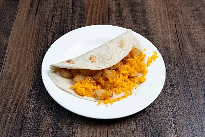A folded flour tortilla taco filled with fried potato and shredded yellow cheese.