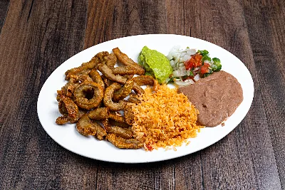 Golden fried tripe with Mexican rice, refried beans, guacamole and pico de gallo on a white oval plate.